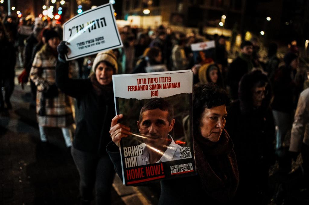 Familias en Israel protestando con fotos de sus familiares que siguen como rehenes.